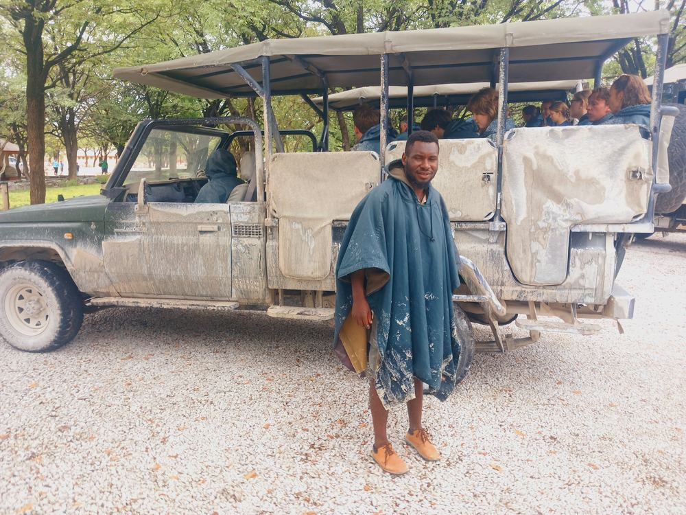 Guide beside the safari vehicle during a golden hour game drive